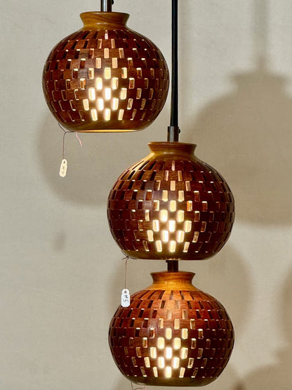 Three-globe handmade bloodwood and canarywood pendant chandelier against a neutral background, showing full cascading arrangement