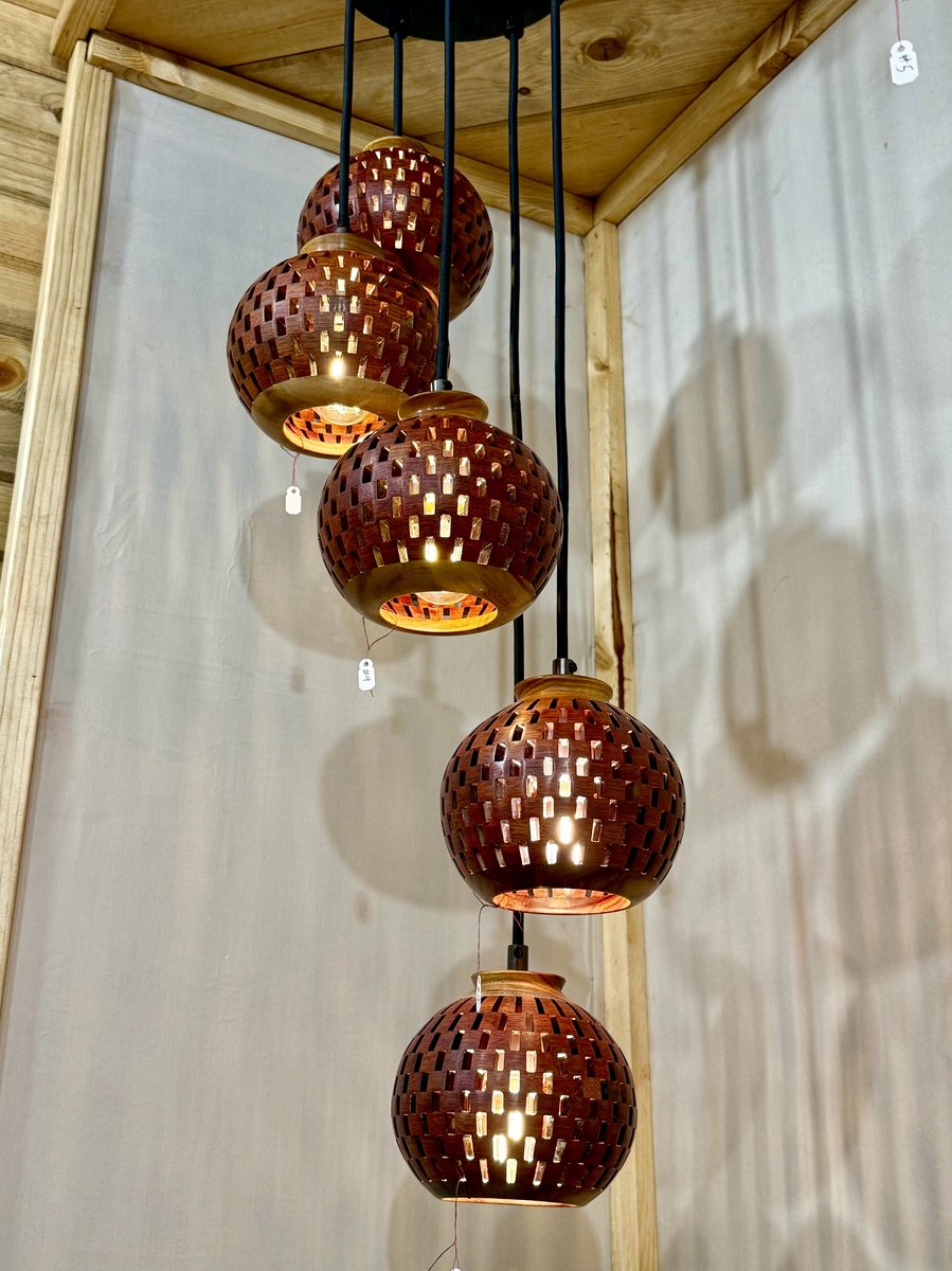 Five-globe handmade bloodwood and canarywood pendant chandelier in a cascading spiral arrangement on display
