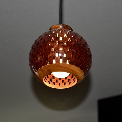 Handmade bloodwood globe pendant light against a dark background, highlighting the spherical open-segment design