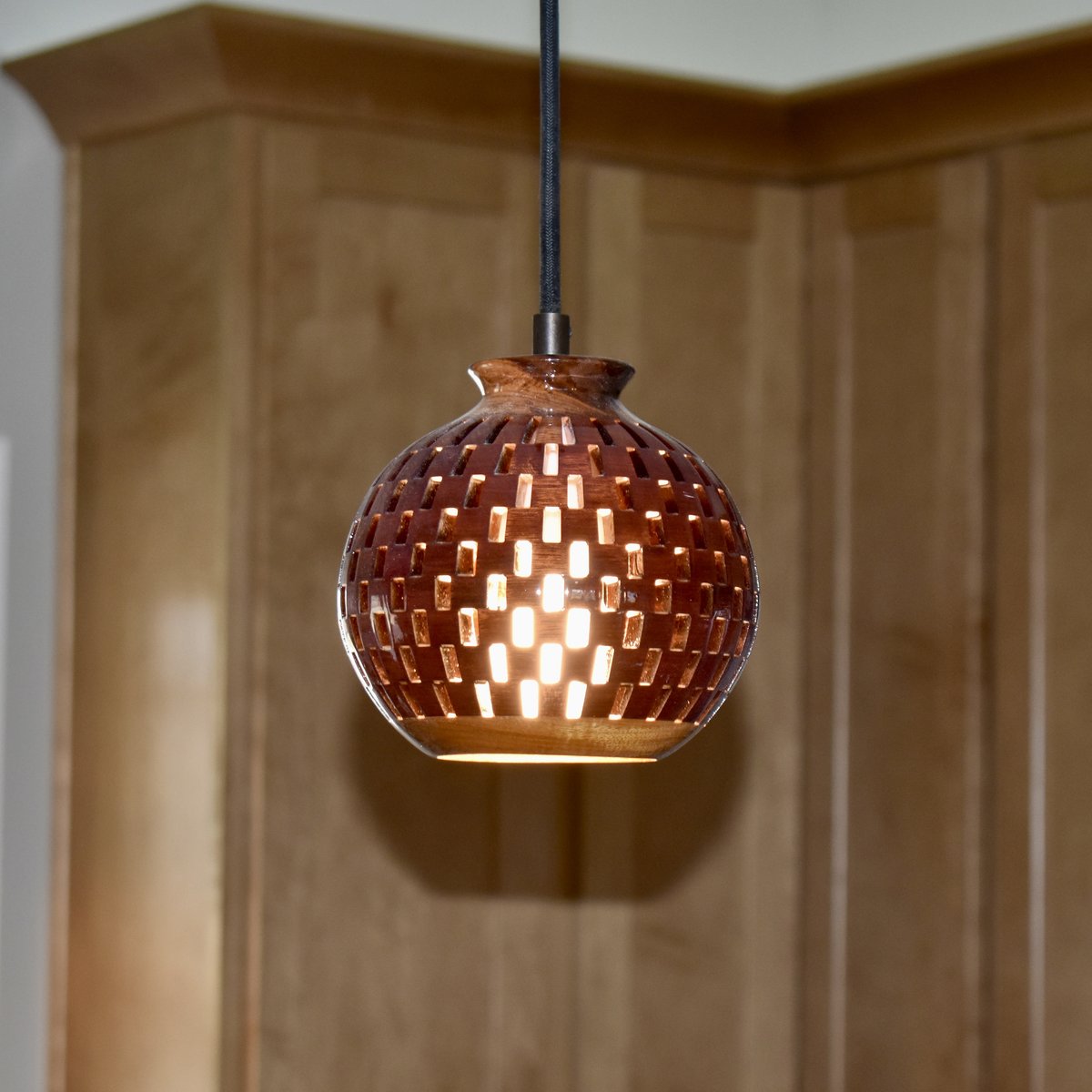Handmade bloodwood globe pendant light product shot showing full sphere shape illuminated