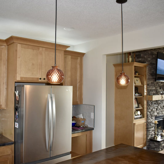 Wide kitchen view featuring handmade bloodwood globe pendant lights providing warm ambient lighting over a kitchen island